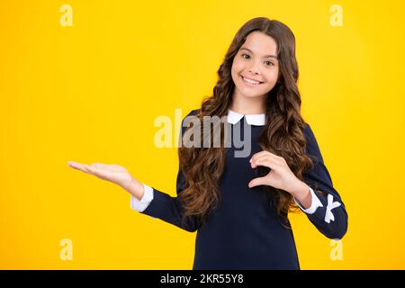 Wow, es ist unglaublich. Schockiert Teenager Kind zeigt beiseite auf den Kopierraum. Teen Mädchen zeigt mit zwei Händen und Fingern zur Seite. Stockfoto