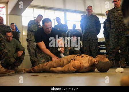 USA Navy Petty Officer 3. Class Tanner Robinson, ein Ausbilder beim Navy Education and Training Office, Division Schools, 1. Marine Division, Demonstriert, wie man Gaze auf einem simulierten Opfer einpackt, während eines taktischen Kampfpflegekurses für religiöse Programmmitarbeiter, der vom gesamten Bereich des Marine Corps Base Camp Pendleton, Kalifornien, am 8. November 2022 abgezogen wurde. TCCC will die Zahl der Todesfälle im Kampf verringern und gleichzeitig eine Einheit in die Lage versetzen, ihre Mission zu erfüllen und die bestmögliche Versorgung für die Opfer auf dem Schlachtfeld zu gewährleisten. Stockfoto