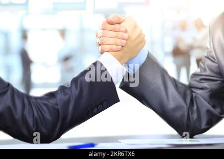 Schließen. Geschäftsleute konkurrieren im Armdrücken. Das Konzept des Wettbewerbs. Vor dem Hintergrund eines Arbeitsteams Stockfoto