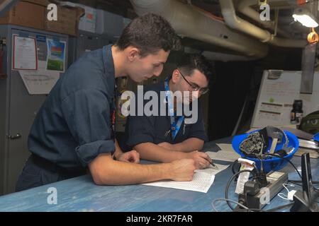 Electrician’s Mate (Nuclear) 3. Class Joseph Josselson, Left, from Parma, Ohio, and Machinist’s Mate (Nuclear) 3. Class Alexander Garza, from Tuscon, Arizona, beide dem Flugzeugträger USS John C. Stennis (CVN 74) zugewiesen, unterzeichnen Wartungsunterlagen an Bord des Schiffes in Newport News, Virginia, 9. November 2022. John C. Stennis arbeitet in Newport News Shipyard zusammen mit NNS, NAVSEA und Auftragnehmern, die im Rahmen der Mission, das Kriegsschiff rechtzeitig und im Rahmen des Budgets wieder in den Kampf zurückzubringen, ihre Pflicht zur Verteidigung der Vereinigten Staaten wiederaufnehmen. Stockfoto