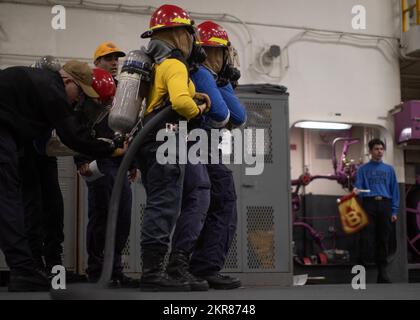 221109-N-LZ839-1062 NORFOLK, VA (9. Nov. 2022) Amphibienschiff USS Bataan (LHD 5) Seeleute des Luftministeriums nehmen an einer Ausbildung des Schlauchteams Teil, die am 9. Nov. 2022 während einer Übung zur Brandbekämpfung in der Hangarbucht des Schiffes durchgeführt wurde. Bataan führt regelmäßig Übungen für Verletzte durch, um die Fähigkeit zur Schadensbegrenzung aufrechtzuerhalten. Stockfoto