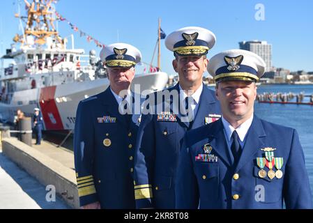 Leutnant Cmdr. Tyler Kelley, kommandierender Offizier des William Chadwick (rechts), Rear. ADM. John Mauger, First Coast Guard District Commander (Mitte), und Admiral Steven Poulin, Vice Commandant of the Coast Guard (links), stehen am 10. November 2022 auf der Pier-Seite des neu in Auftrag gegebenen Küstenwache Cutter William Chadwick (WPC-1150) in Boston, Massachusetts. Der neueste Cutter der Küstenwache wurde am 4. August von der Küstenwache angenommen und wird der erste von sechs Fast Response Cuttern sein, die nach Boston Homeportiert werden. Stockfoto