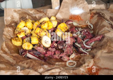 Mitchopo (gegrilltes Fleisch), serviert in der Zeitung, in der es gekocht wird, Kamalondo, Luubumbashi, Demokratische Republik Kongo. Stockfoto