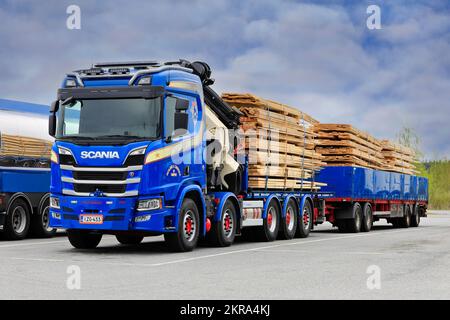 Maßgeschneiderter blauer Scania Lkw mit Palfingerkran, der auf dem Rastplatz geparkt ist, bereit für den Transport von Schnittholz. Forssa, Finnland. 14. Mai 2021. Stockfoto