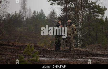 USA Army Sgt. Hunter Moffatt, ein Kampfarzt der 6.. Staffel, 9.. Kavallerie-Regiment, 3.. Bewaffnete Brigaden-Kampfeinheit, 1.. Kavallerie-Division (3-1 ABCT), operativ der 1.. Infanterie-Division (1 ID) zugeteilt, spricht mit einem finnischen Soldaten während einer simulierten Kampfübung bei Hammer 22, Eine jährliche Übung der kombinierten Kräfte, die vom finnischen Hauptquartier der Armee, der Panzerbrigade, der Pori-Brigade, der Karelia-Brigade, dem UTI Jaeger-Regiment und dem Logistikministerium der Streitkräfte in Niinisalo, Finnland, am 10. November 2022 durchgeführt wird. Das 3-1 ABCT ist unter anderem dem 1 ID zugewiesen Stockfoto