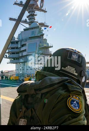 ATLANTIK (11. November 2022) Ein Besatzungsmitglied der Royal Canadian Air Force bereitet einen Royal Canadian Navy Cyclone Helicopter vor, der an der Fregatte HMCS Montreal (FFH 336) der Halifax-Klasse befestigt ist und auf der USS Gerald R. Ford (CVN 78) am 11. November landen soll. Montreal ist der Gerald R. Ford Carrier Strike Group angeschlossen, die im Atlantik eingesetzt wird und neben den NATO-Alliierten und Partnern Schulungen und Operationen durchführt, um die Integration für zukünftige Operationen zu verbessern und die USA zu demonstrieren Engagement der Marine für eine friedliche, stabile und konfliktfreie Atlantikregion. Stockfoto