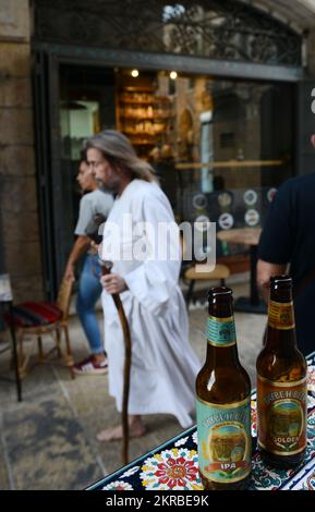 Genießen Sie ein kaltes palästinensisches Taybritbier in einem Café/einer Bar in der lebhaften New Gate Street im christlichen Viertel in der Altstadt von Jerusalem. Stockfoto