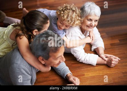 Enkel sind ein Segen. Gruppenfoto von einem Bruder und einer Schwester, die sich mit ihren Großeltern anfreunden. Stockfoto