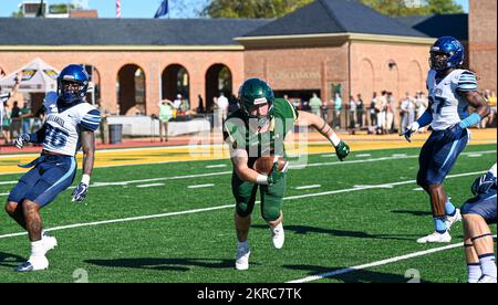 Bronson Yoder, William and Mary Tribe Football Player, läuft durch Tyrell Mims, Villanova Wildcats Football Player, Left, und Danny Abraham, Villanova Wildcats Football Player, Right, während der USA Militärisches Würdigungsspiel am College of William and Mary, Williamsburg, Virginia, 12. November 2022. Im Rahmen der Eröffnungszeremonie und zur Anerkennung von Mitgliedern des Dienstes wurden die Farben präsentiert und drei Chinook-Hubschrauber der Boeing CH-47 flogen während der Nationalhymne über das Feld. Stockfoto