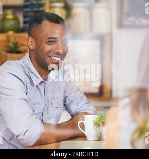 Ich bin so froh, dass wir uns treffen konnten. Ein junger Mann, der mit seiner Freundin Kaffee trinkt. Stockfoto