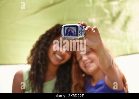 Wir werden für immer beste Freunde sein. Zwei junge Freunde machen ein Foto von sich, während sie auf einem Campingausflug sind. Stockfoto