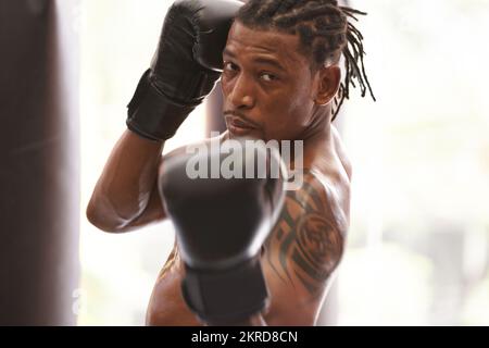 Ein mittlerer oberer Schnitt. Porträt eines jungen Boxers, der im Fitnessstudio trainiert. Stockfoto