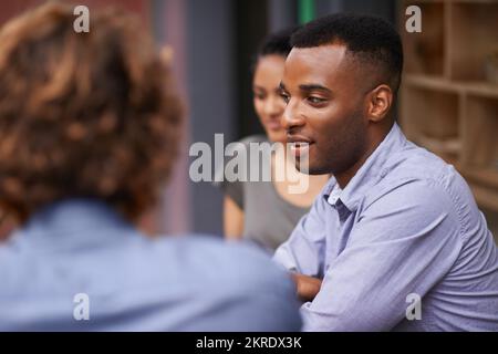 Wir haben uns unterhalten, während wir rumhängen. Freunde, die sich unterhalten, während sie in einem Restaurant sitzen. Stockfoto