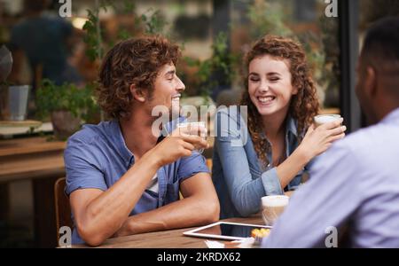 Wir haben uns unterhalten, während wir rumhängen. Eine Gruppe von Freunden, die sich in einem Café unterhalten. Stockfoto