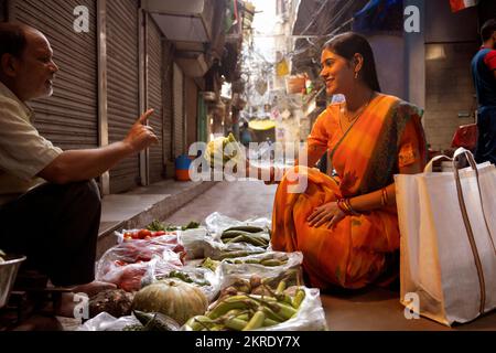 Eine Frau, die Gemüse vom Straßenmarkt kauft Stockfoto