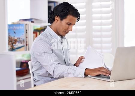 Es ist schwer, aus dem Internet zu bleiben. Beschnittene Seite eines gutaussehenden Geschäftsmanns, der von zu Hause aus arbeitet. Stockfoto