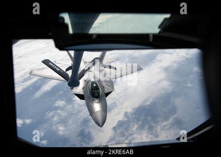 EIN US-AMERIKANISCHER Air Force F-22A Raptor im 3.. Flügel, vorübergehend auf dem Kadena-Luftwaffenstützpunkt, Japan stationiert, bereitet sich darauf vor, Treibstoff von einem KC-135 Stratotanker zu nehmen, der der 909.. Luftbetankungsschwadron zugeteilt wurde, um Treibstoff während der Übung Keen Sword 23 über dem Pazifischen Ozean zu erhalten, am 15. November 2022. Übungen wie Keen Sword 23 zeigen, dass sich die Vereinigten Staaten und Japan stark und gemeinsam für ein freies und offenes Indo-Pacific einsetzen. Stockfoto