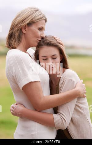 Ich bin stolz auf die Frau, zu der sie heranwächst. Eine Mutter, die ihre Erwachsene Tochter umarmt. Stockfoto