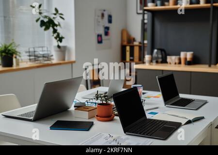Horizontales Bild des Arbeitsplatzes von Büroangestellten mit Laptops für Online-Arbeiten im IT-Büro Stockfoto