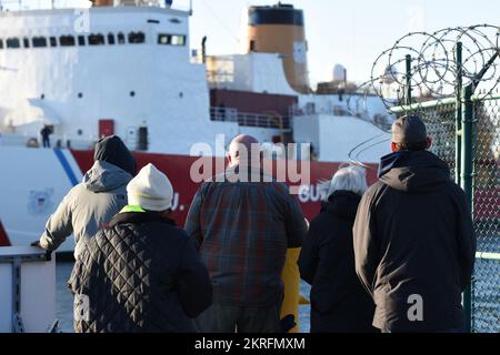 Familie und Freunde beobachten, wie die Crew an Bord von Coast Guard Cutter Polar Star (WAGB 10) den Base Seattle Pier am 16. November 2022 verlässt und eine Reise in die Antarktis zur Unterstützung der Operation Deep Freeze beginnt. Operation Deep Freeze ist die jährliche gemeinsame Militärmission zur Nachlieferung der antarktischen Stationen der Vereinigten Staaten zur Unterstützung der National Science Foundation, der federführenden Behörde des United States Antarctic Program. Stockfoto