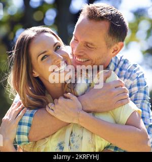 Ich weiß, dass er mich liebt. Porträt eines liebevollen Paares draußen in der Sommersonne. Stockfoto