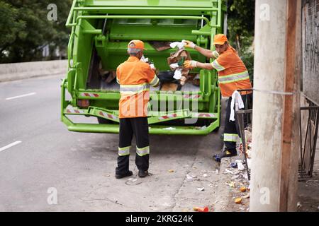 Müllabfuhr-Tag. Ein Müllabfuhr-Team bei der Arbeit. Stockfoto