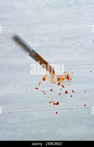 Die Klinge des Messers im Blut liegt auf dem Boden. Messer und Verletzungen, Verbrechen. Stockfoto