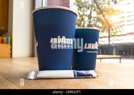 MINSK - JULI 10: Nahaufnahme von zwei Pappbechern auf einem Tisch mit Lavazza-Logo im Minsk Lavazza Café am 10. Juli. 2022 in Weißrussland Stockfoto