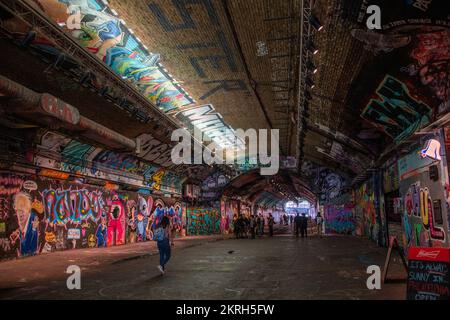 Schöner öffentlicher Ort, um Freunde im Tunnel zu treffen, der mit Graffitis in verschiedenen Farben bemalt ist Stockfoto