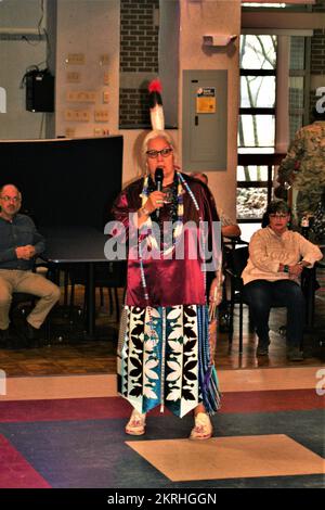 Ein Mitglied der Sänger von Wisconsin Dells der Ho-Chunk Nation of Wisconsin tritt während der 2022 stattfindenden Veranstaltung des Fort McCoy Native American Heritage Month im McCoy's Community Center in Fort McCoy, Wisconsin, auf. Die Sänger spielten traditionelle Musik und Tänze der Ureinwohner in ihren Regalen für Dutzende Mitglieder der Fort McCoy Community. Der November ist der Monat des amerikanischen Ureinwohnerbes, oder wie er gemeinhin als „American Indian and Alaska Native Heritage Month“ bezeichnet wird. Der Monat ist eine Zeit, um reiche und vielfältige Kulturen, Traditionen und Geschichte zu feiern und die wichtigen Beiträge der Ureinwohner zu würdigen. Stockfoto