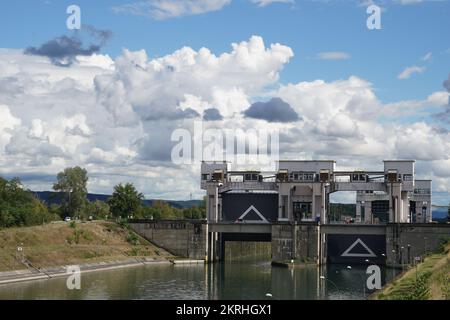 Blick auf zwei Schleusen mit einem offenen Tor neben dem Wasserkraftwerk Kembs am Rhein. Stockfoto