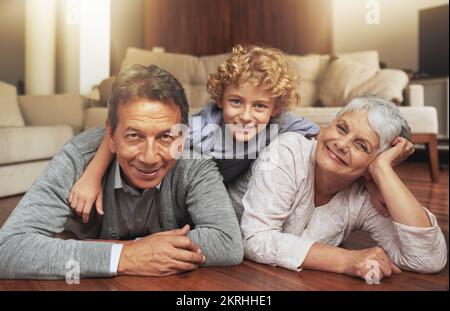 Wir hängen bei Grandpa und Grandmas ab. Ein älteres Paar, das Zeit mit seinem Enkel zu Hause verbringt. Stockfoto