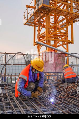 Chongqing. 28.. November 2022. Auf der Baustelle der Huafu-Mega-Brücke im Abschnitt Sichuan-Chongqing der Hochgeschwindigkeitsbahn Chongqing-Kunming in der Gemeinde Chongqing im Südwesten Chinas sind am 28. November 2022 Arbeiter im Dienst. Die 699 km lange Hochgeschwindigkeitsbahn Chongqing-Kunming mit einer geplanten Geschwindigkeit von 350 km/h ist ein wichtiger Bestandteil des Eisenbahnkorridors, der die chinesische Hauptstadt Peking mit Kunming in der südwestchinesischen Provinz Yunnan verbindet. Kredit: Zhu Gaoxiang/Xinhua/Alamy Live News Stockfoto