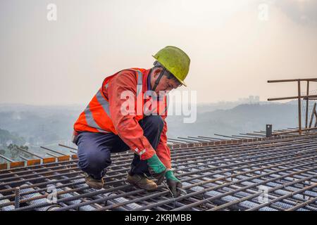 Chongqing. 28.. November 2022. Ein Arbeiter ist auf der Baustelle der Huafu-Mega-Brücke am Abschnitt Sichuan-Chongqing der Hochgeschwindigkeitsbahn Chongqing-Kunming in der Gemeinde Chongqing im Südwesten Chinas am 28. November 2022 im Dienst. Die 699 km lange Hochgeschwindigkeitsbahn Chongqing-Kunming mit einer geplanten Geschwindigkeit von 350 km/h ist ein wichtiger Bestandteil des Eisenbahnkorridors, der die chinesische Hauptstadt Peking mit Kunming in der südwestchinesischen Provinz Yunnan verbindet. Kredit: Zhu Gaoxiang/Xinhua/Alamy Live News Stockfoto