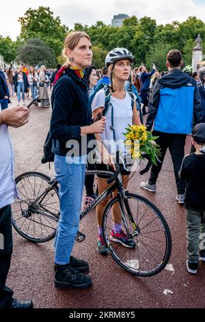 Eine junge Frau wartet darauf, Nach dem Tod von Königin Elisabeth II., London, Großbritannien, Eine Blumenmedaille an den Toren des Buckingham-Palastes niederzulegen. Stockfoto