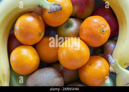 Eine Schüssel mit gemischten Zitrusfrüchten, Äpfeln, Satsumas, Kiwis und Bananen - eine gute Faserquelle und 5 pro Tag. Konzept - gesunde Ernährung, essen mehr Obst Stockfoto