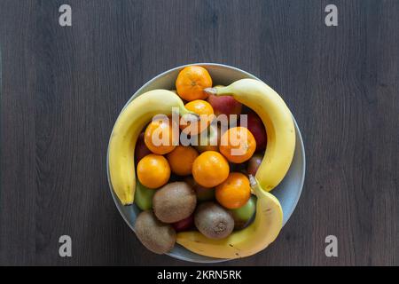 Eine Schüssel mit gemischten Zitrusfrüchten, Äpfeln, Satsumas, Kiwis und Bananen - eine gute Faserquelle und 5 pro Tag. Konzept - gesunde Ernährung, essen mehr Obst Stockfoto