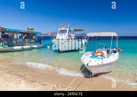 Zakynthos, Griechenland - 16. August 2016: Motorboot vor Anker am Strand, Touristen schwimmen in der Nähe Stockfoto