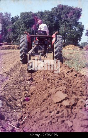 Traktoren werden im Allgemeinen mit der Landwirtschaft in Verbindung gebracht, da Landwirte sie neben Maschinen einsetzen, um Arbeitsgeräte wie Pflügen, Pflügen, Aussaaten und Eggen zu betreiben. Außerdem wird ein Traktor zum Schieben oder Ziehen der Maschine verwendet, wodurch die landwirtschaftliche Arbeit bequemer wird. Stockfoto