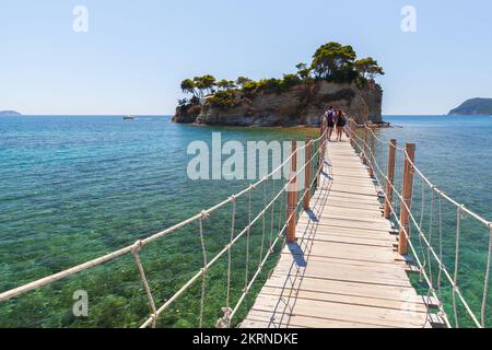 Zakynthos, Griechenland - 17. August 2016: Touristen gehen an einem sonnigen Sommertag über die Brücke zur Insel Cameo Stockfoto