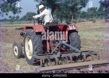 Traktoren werden im Allgemeinen mit der Landwirtschaft in Verbindung gebracht, da Landwirte sie neben Maschinen einsetzen, um Arbeitsgeräte wie Pflügen, Pflügen, Aussaaten und Eggen zu betreiben. Außerdem wird ein Traktor zum Schieben oder Ziehen der Maschine verwendet, wodurch die landwirtschaftliche Arbeit bequemer wird. Stockfoto