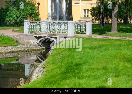 Dekorative Fußgängerbrücke über einen kleinen Kanal im Park Stockfoto