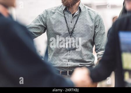 Geschäftsleute schütteln sich die Hand, während sie sich treffen und Werbematerial und Broschüren zu geschäftlichen Treffen auf Messen austauschen. Geschäftsgespräch Geschäftskonzept Stockfoto