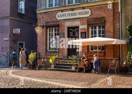 Danzig, Polen - 22. Mai 2022: Café-Fassade in der Abendsonne. Altstadt in Europa bei Sonnenuntergang Stockfoto