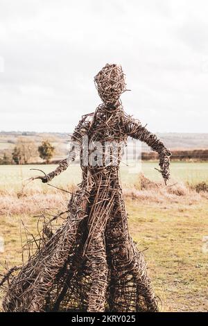 Die Korbhexenskulptur bei den Rollright Stones in Oxfordshire an einem kalten, nebligen Wintertag. Stockfoto