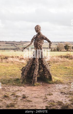 Die Korbhexenskulptur bei den Rollright Stones in Oxfordshire an einem kalten, nebligen Wintertag. Stockfoto