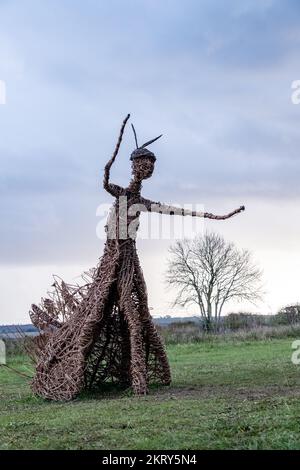 Die Korbhexenskulptur bei den Rollright Stones in Oxfordshire an einem kalten, nebligen Wintertag. Stockfoto