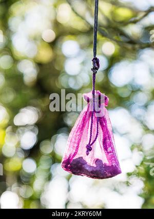 Wicca-Geschenke/-Angebote in Form von Federn, farbigen Bändern und Maisohren, die an die Bäume in der Nähe der jungsteinzeitlichen Rollright Stones in Oxfordshire gebunden sind. Stockfoto