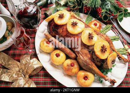 Gebratene Gans, garniert mit Apfelscheiben und Spargelspitzen Stockfoto