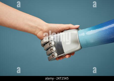 Nahaufnahme einer Person, die dem Roboter die Hand schüttelt, Konzept der künstlichen Intelligenz Stockfoto